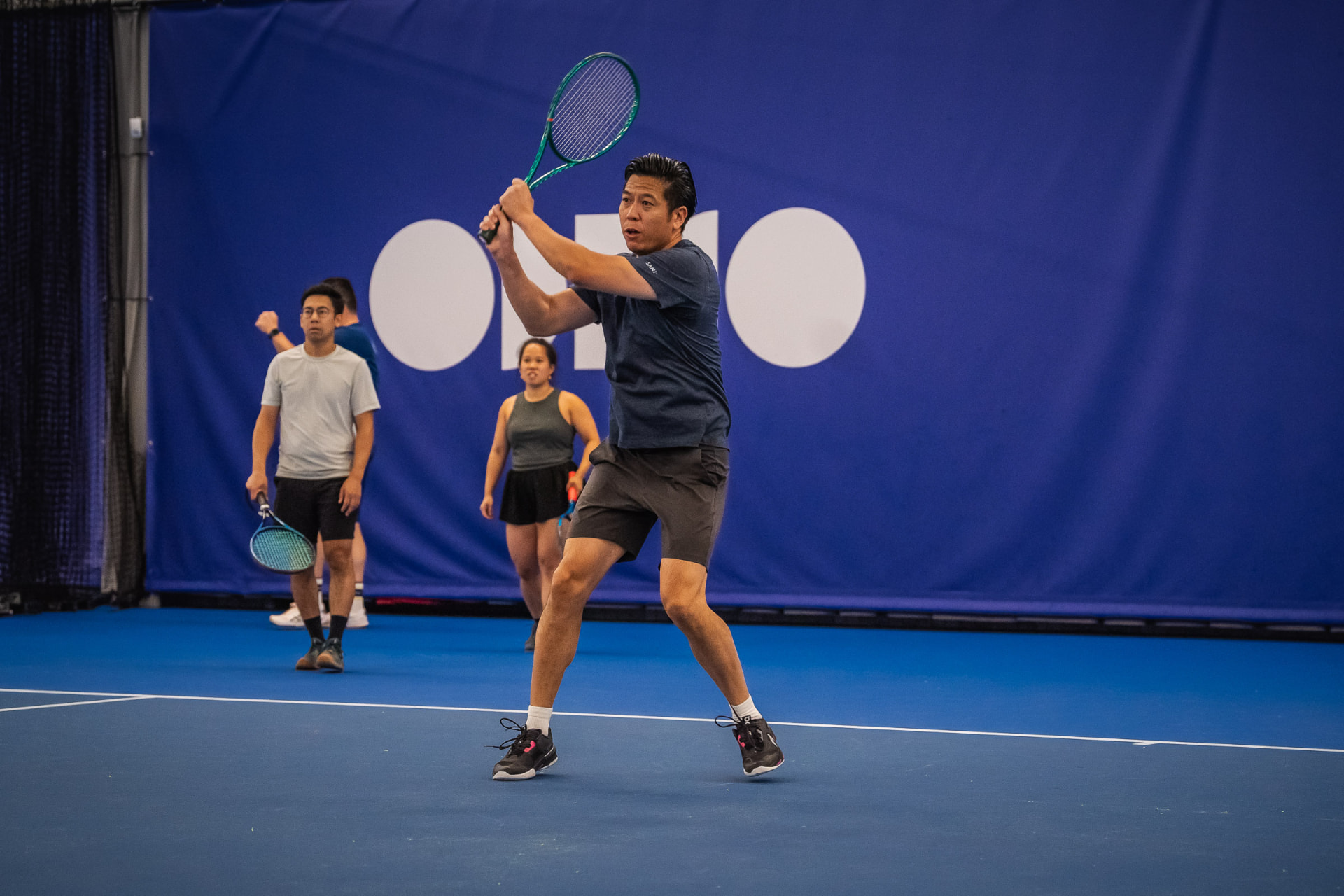 Volwassen speler slaat backhand tijdens indoor tennisles NTC Amstelveen — 359.tennis